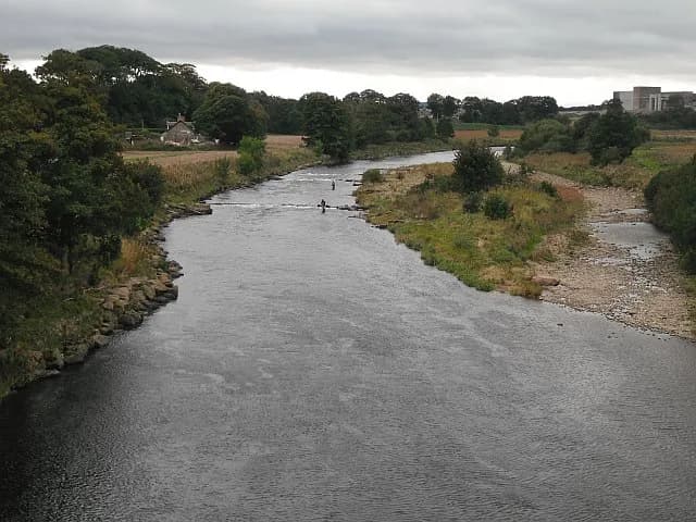 The River North Esk in Angus, Scotland, with anglers fishing from the Kincardineshire bank.