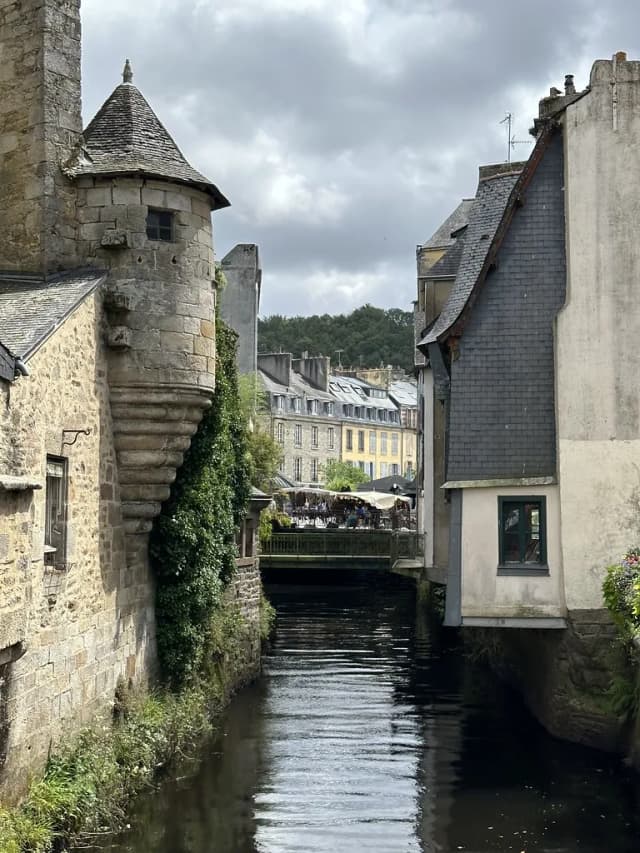 The narrow Steir river channel lined with medieval stone and slate-roofed buildings in Quimper, France.