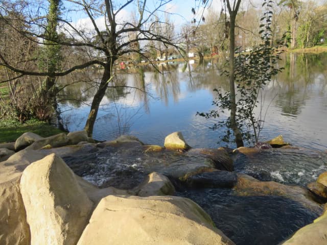 Lac de Gravelle in the Bois de Vincennes, Paris, with reflections of trees and lakeside buildings