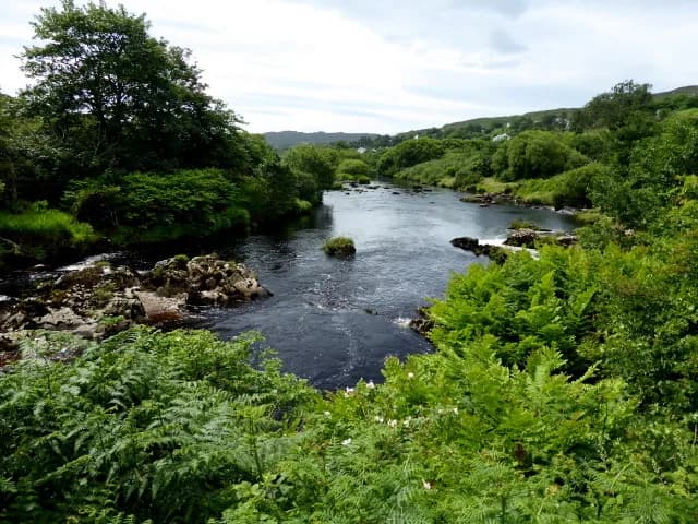 The Glen River flowing through Carrick, County Donegal, with green banks either side.
