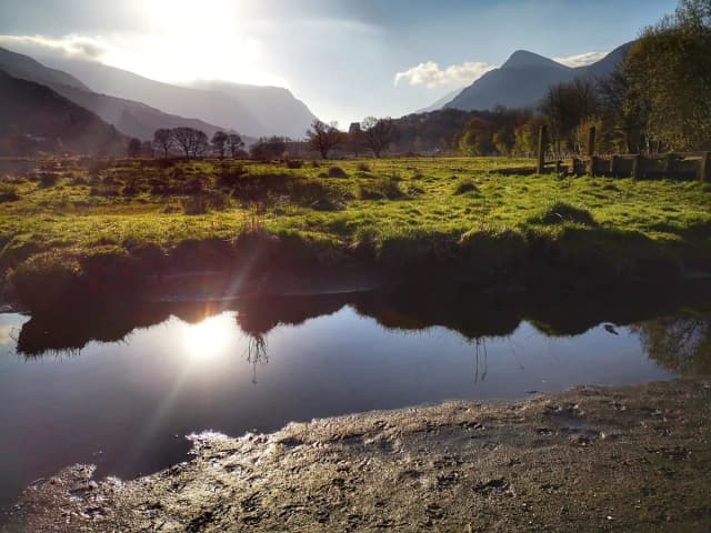 Llyn Padarn lake at Llanberis on a calm morning, with Snowdonia's mountains beyond the water.