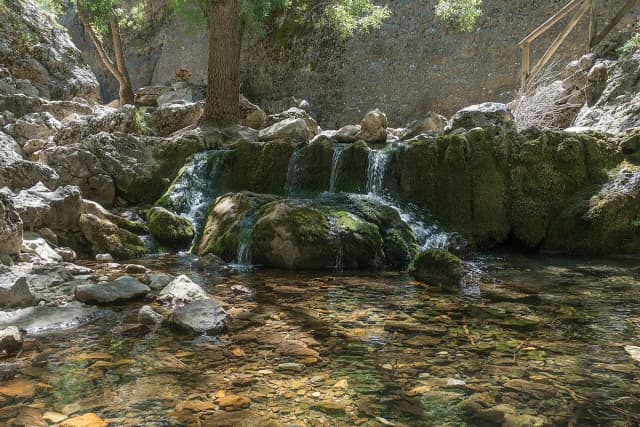 Clear spring water cascading over moss-covered rock at the source of the Guadalquivir river in the Sierra de Cazorla natural park