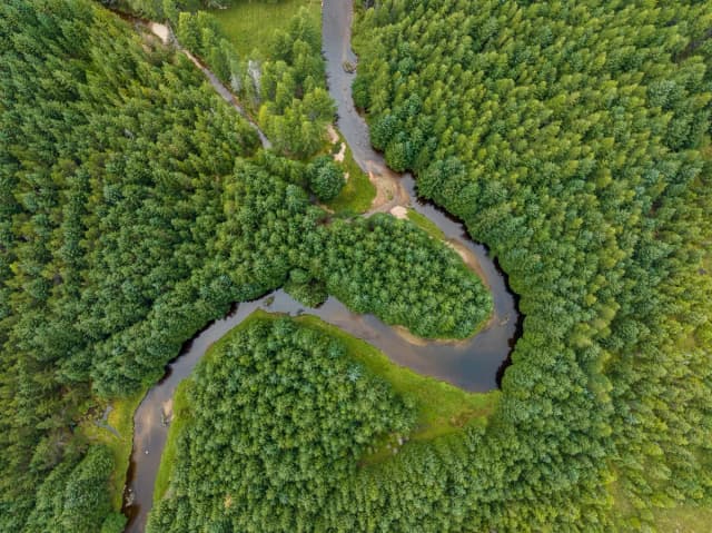 The River Muick flowing through moorland and hills in the Cairngorms National Park, Scotland.