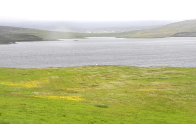Loch of Vaara, a Shetland freshwater loch between Twatt and Clousta, with moorland shoreline and open sky.