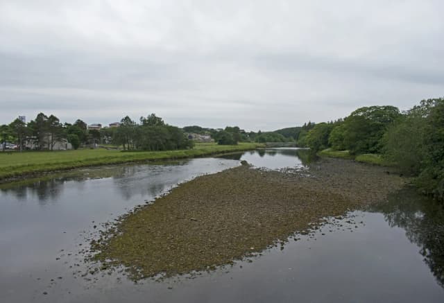 A view upstream along the River Thurso from Thurso Bridge in Caithness, Scotland, with open water and low countryside banks.