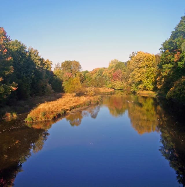 Fishkill Creek lined with autumn foliage, reflecting the trees and sky