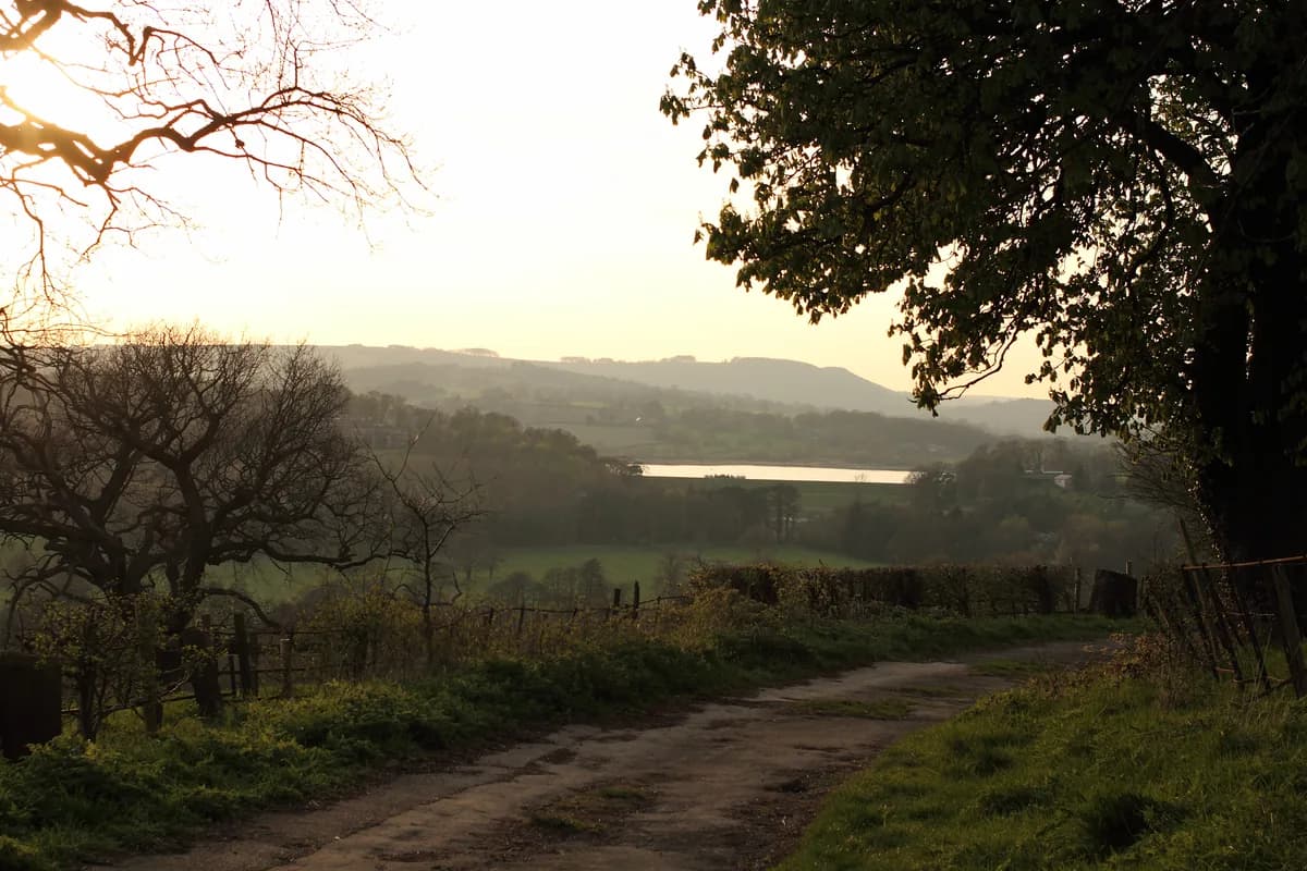 Wide view across Ogston Reservoir with surrounding Derbyshire countryside under an open sky.