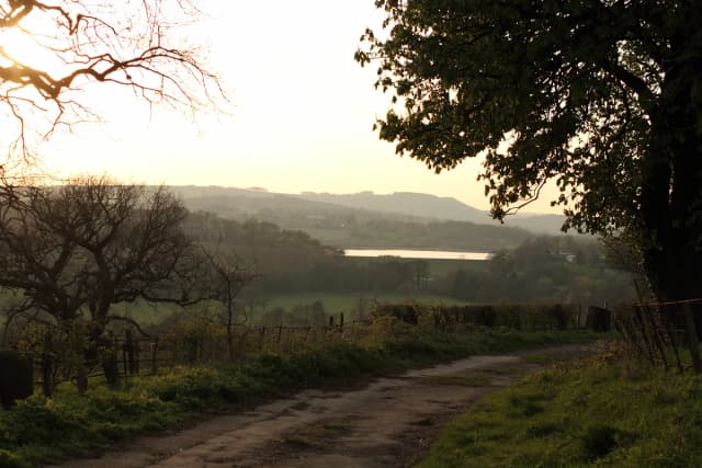 Wide view across Ogston Reservoir with surrounding Derbyshire countryside under an open sky.