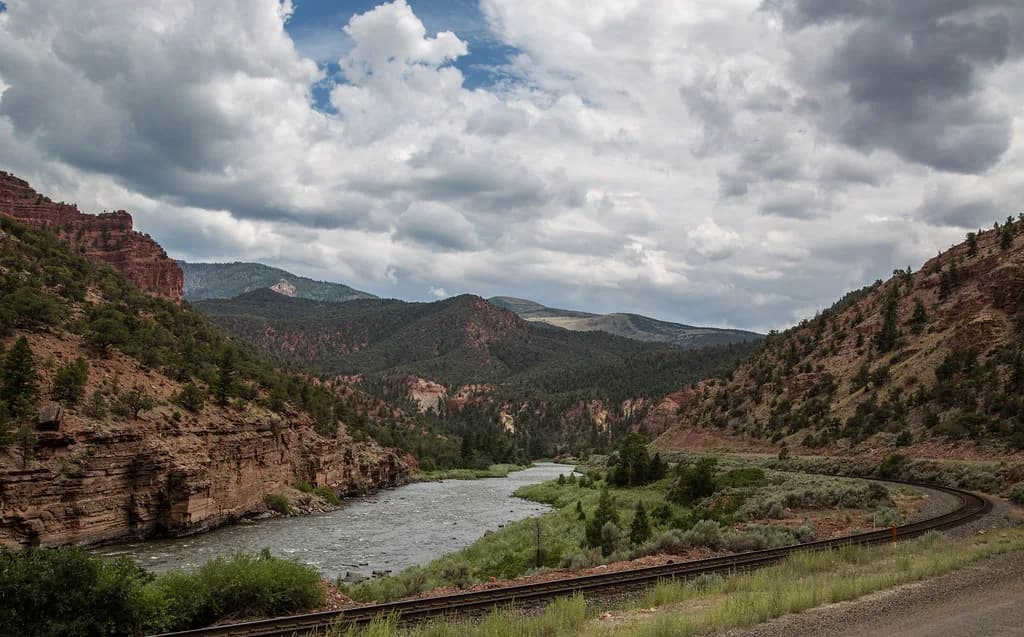 The Colorado River flowing through a red-rock canyon between Burns and Dotsero, Colorado, with a rail line following the bank.