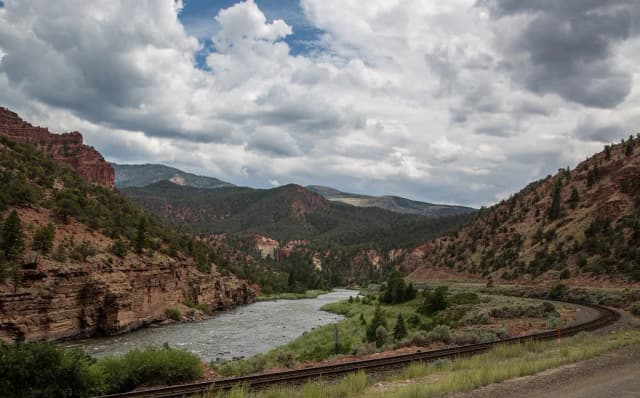 The Colorado River flowing through a red-rock canyon between Burns and Dotsero, Colorado, with a rail line following the bank.