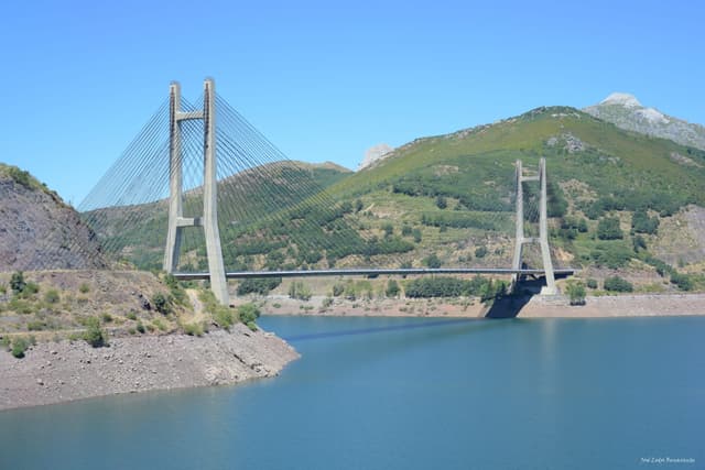The Carlos Fernández Casado cable-stayed bridge over the blue-green waters of Barrios de Luna reservoir.