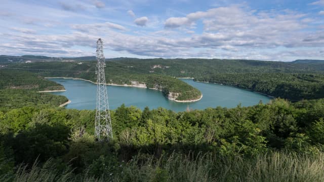 Turquoise waters of Lac de Vouglans winding through forested limestone hills, Jura, France