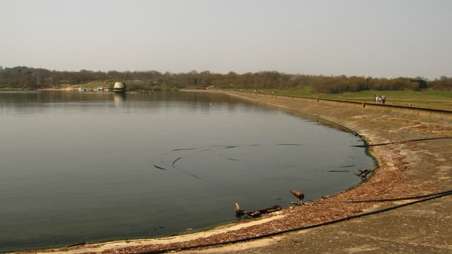 The earthen dam at Bewl Water photographed from the water side, showing the dam face and open reservoir.