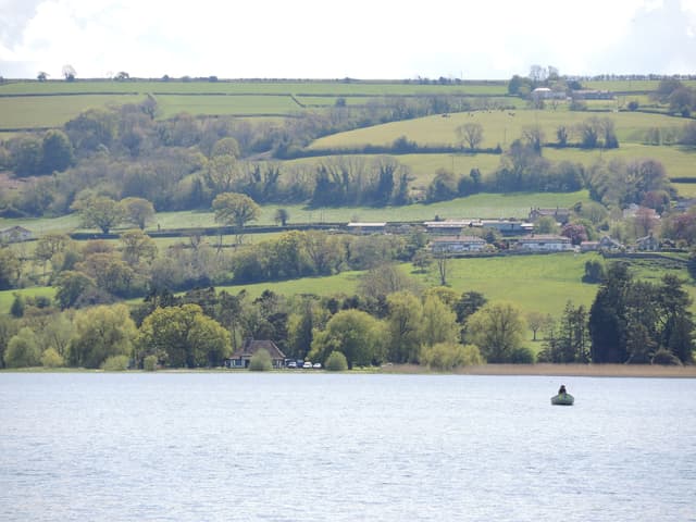 Fly-fishing boats spread across the open water of Blagdon Lake on a busy fishing day.