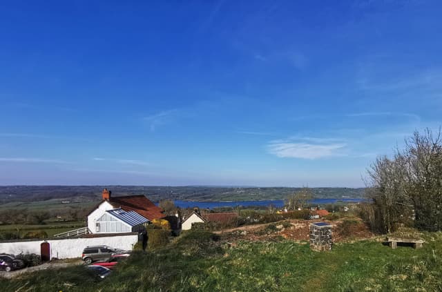 Wide landscape view across Blagdon Lake and the surrounding Mendip valley from elevated ground.