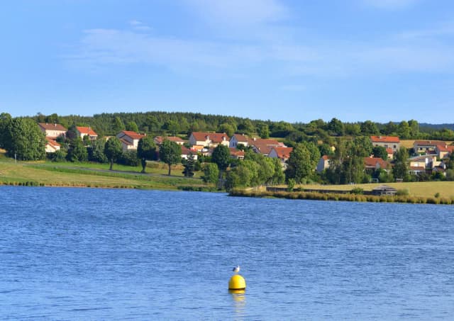 Lac de Naussac reservoir with lakeside village on the far shore, Margeride, Lozère, France