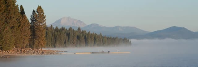Misty morning at Lake Almanor with a fishing boat at the dock and Mount Lassen rising in the background, Plumas County, California
