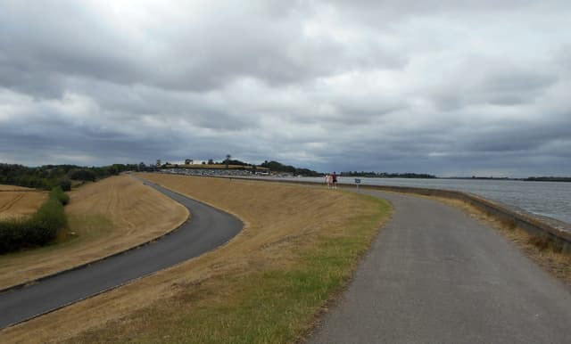 The large eastern dam embankment of Draycote Water reservoir with water visible.