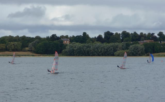 Sailing dinghies on Draycote Water reservoir on a sunny day with open water behind.