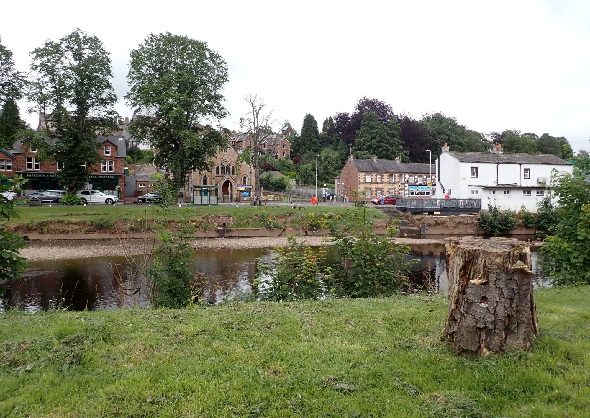 The River Eden flowing through Appleby-in-Westmorland in summer with tree-lined banks and clear water.