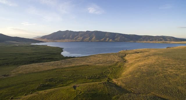 Aerial view of Henrys Lake at sunset with mountains along the far shore, Idaho, Greater Yellowstone region