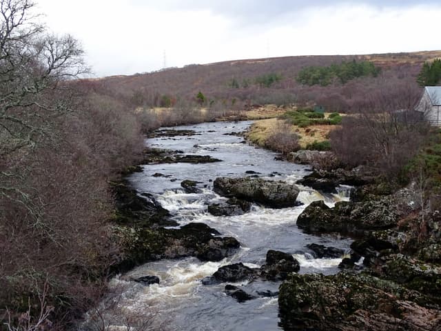 The River Helmsdale flowing through moorland at Kildonan, Sutherland, in winter light.