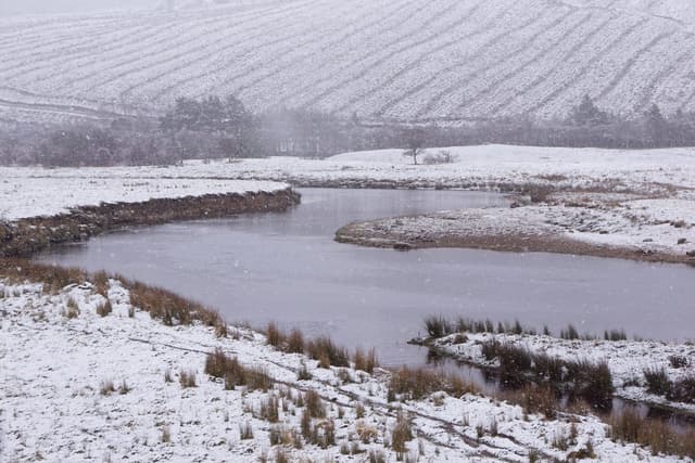 The River Helmsdale at Balvalaich flowing through open Highland glen with heather moorland slopes either side.