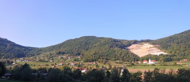 Panoramic view of the Krka at Soteska, Dolenjska, with wooded valley sides and the river reflecting sky.