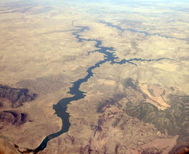 Aerial photograph across La Serena reservoir, the broad open water and surrounding low hills.