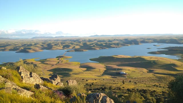 La Serena reservoir seen from the Sierra de Lares ridge, wide open water and dehesa landscape.