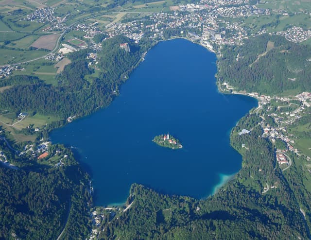 Aerial view of Lake Bled from the southwest, the whole lake, island church, castle cliff and the Julian Alps.