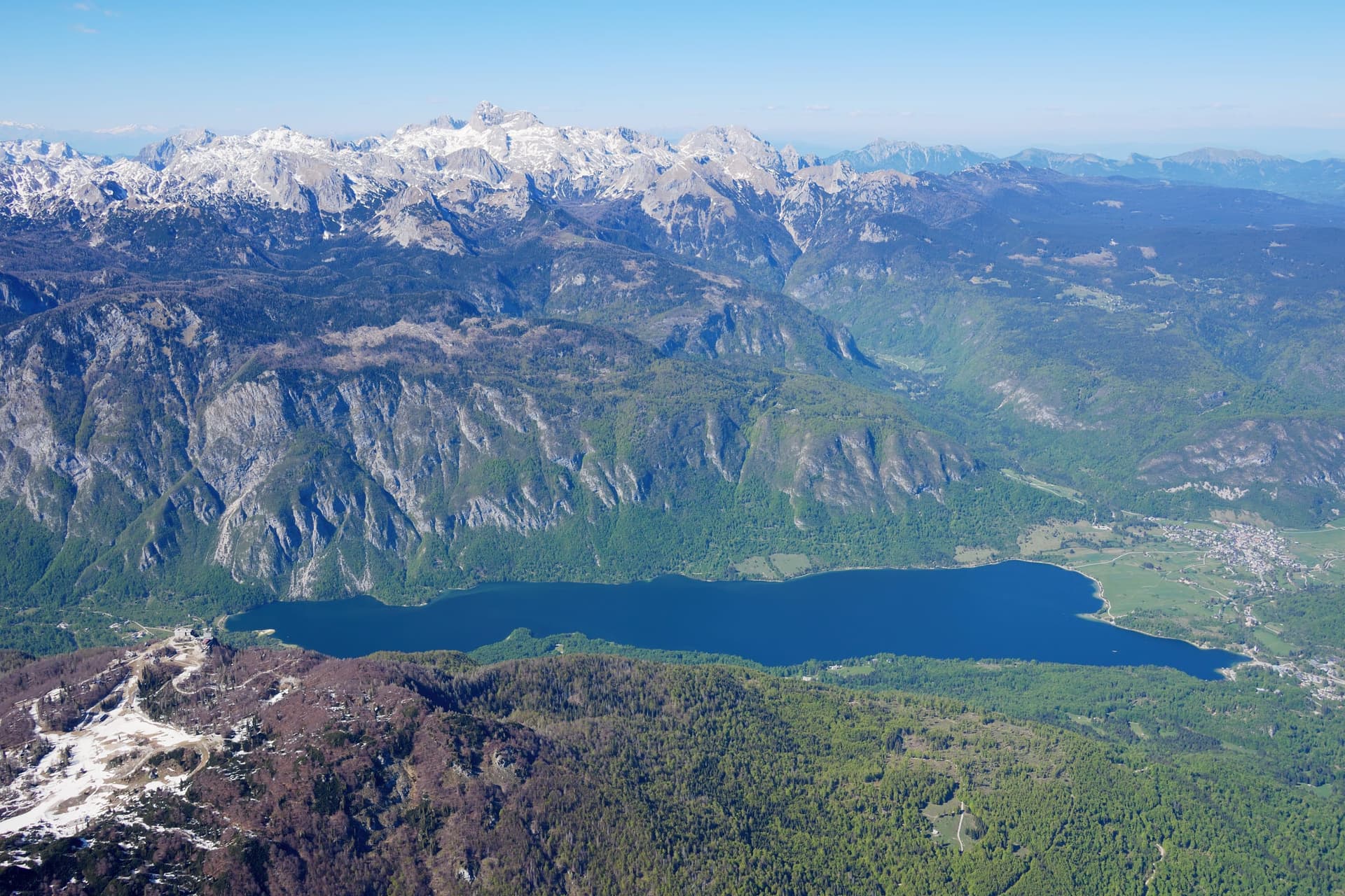 Aerial view of Lake Bohinj looking south, the whole glacial lake against the Julian Alps and Triglav.