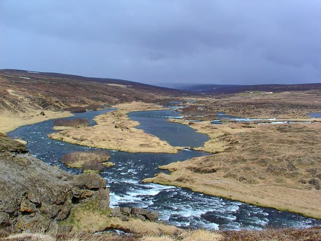 The Laxá flowing toward Lake Mývatn through low green meadows, north Iceland.