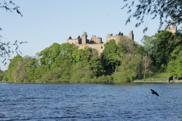 View from the water looking east along Linlithgow Loch towards Linlithgow Palace rising on the shoreline.