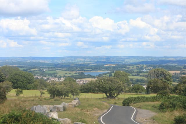 Llandegfedd Reservoir as a blue expanse in the rolling Welsh landscape, from the mountain road south of Pontypool.