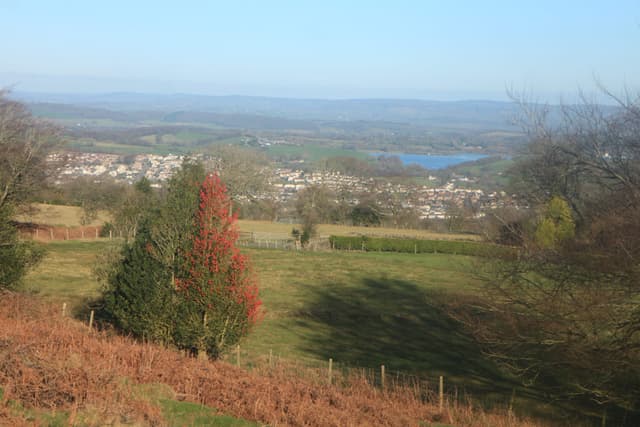 Llandegfedd Reservoir glowing bright blue against the Welsh countryside, from the mountainside north of Blaen Bran.