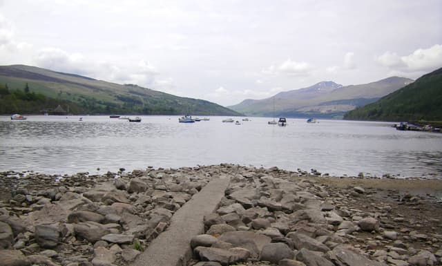 Small boats moored on Loch Tay at Kenmore with the broad loch stretching west into the hills.