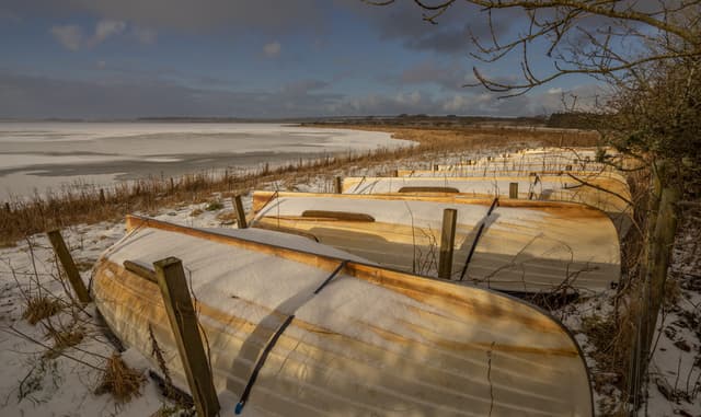 A winter's day at Loch Watten, Caithness, with fishing boats laid up on the shore awaiting the new season.