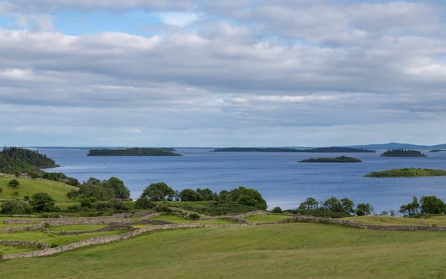 Broad view of Lough Corrib near Clonbur, open lake water with stone walls and green countryside.