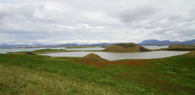 Rootless pseudocrater cones of Skútustaðir reflected in the still water of Lake Mývatn.