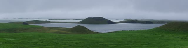 The Skútustaðir pseudocraters rising from the calm surface of Lake Mývatn, Iceland.