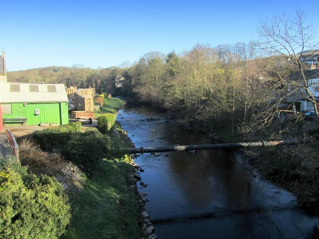 The River Nidd flowing through a wide wooded valley below Summerbridge in Nidderdale in late winter.