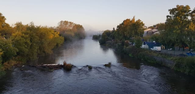 The River Nore drifting through Kilkenny town in early morning fog.