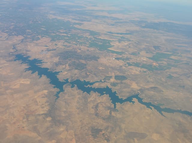 Aerial view over the broad open surface of Embalse de Orellana, Badajoz, Extremadura.