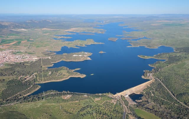 Ground-level view of the Orellana La Vieja dam and the broad reservoir behind it.