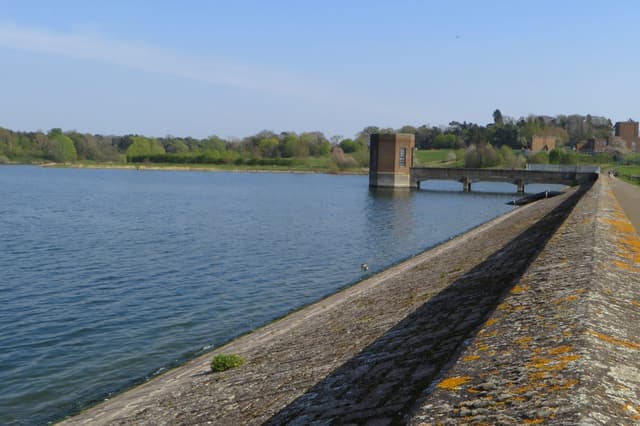 The Victorian draw-off tower standing in Pitsford Reservoir with open water and surrounding woodland.