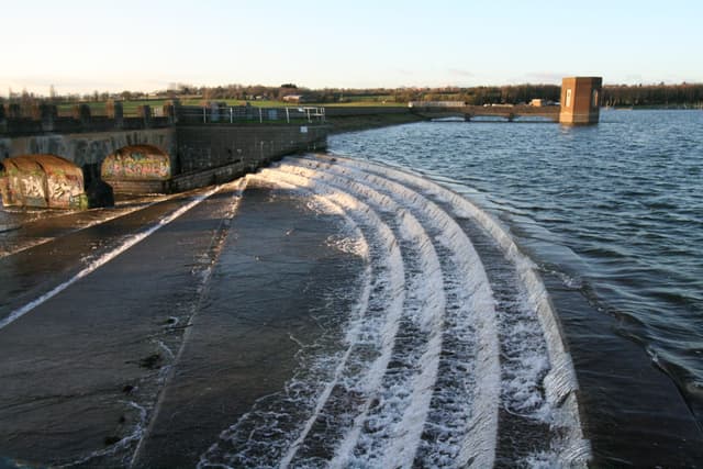 Pitsford Reservoir in winter with the dam embankment and open water extending across the frame.
