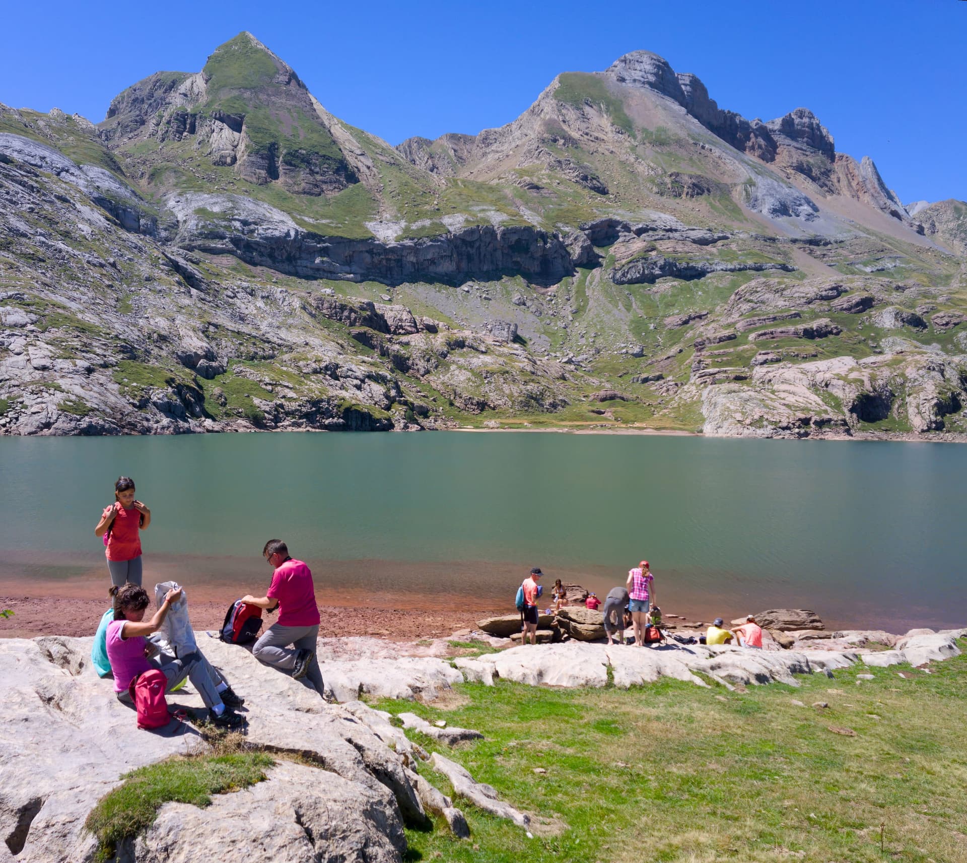 The blue glacial waters of Ibón de Estanés in the Aragonese Pyrenees on a clear summer day.
