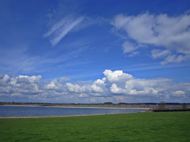 The earthen embankment dam at Rutland Water with the reservoir water visible behind it.