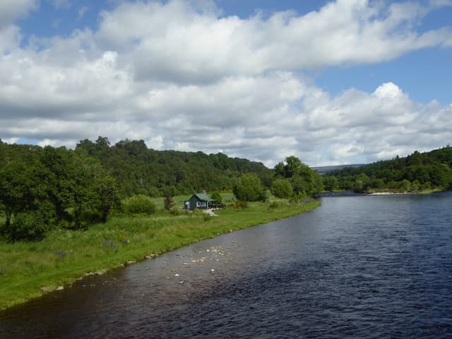 The River Spey at Blacksboat in the Knockando area, wide flow through Speyside landscape under open sky.